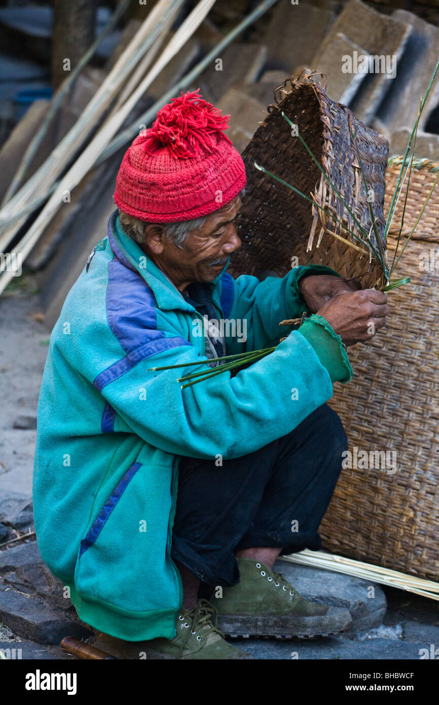 Ein NEPALI Mann repariert ein Bambuskorb, genannt DOLKO - rund um MANASLU Trekking, NEPAL Stockfoto