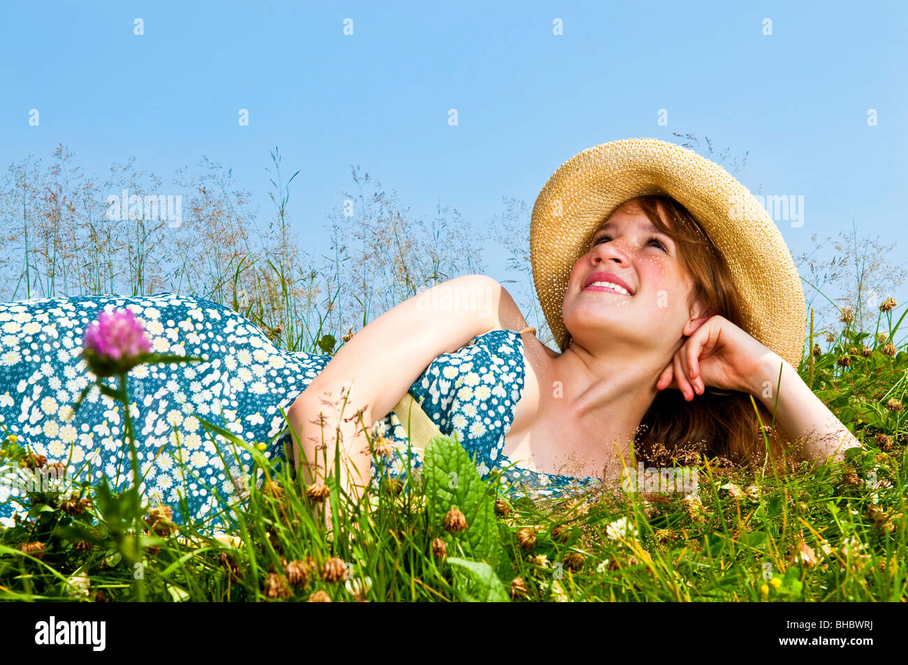 Junge Teenager-Mädchen Handauflegen Sommerwiese im Strohhut nachschlagen Stockfoto