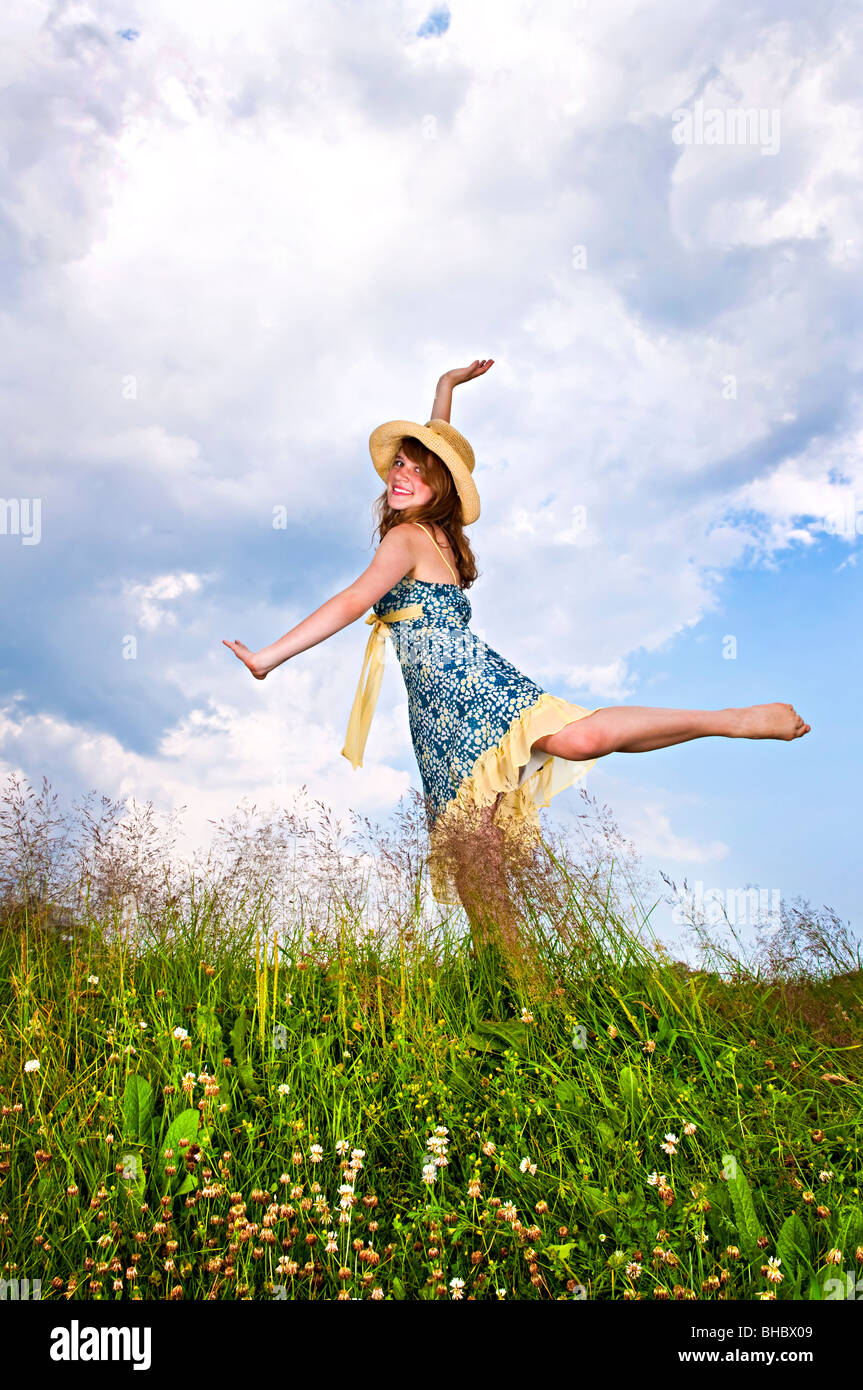 Junge Teenager-Mädchen tanzen in Sommerwiese inmitten von Wildblumen Stockfoto