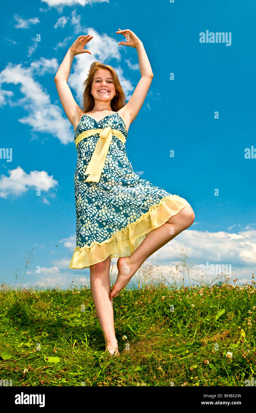 Junge Teenager-Mädchen tanzen in Sommerwiese inmitten von Wildblumen Stockfoto