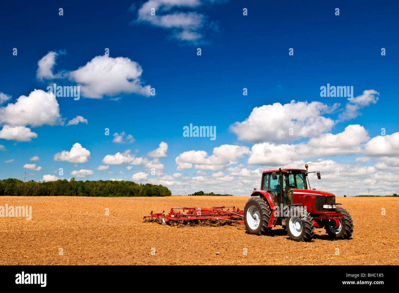 Kleine Landwirtschaft mit Traktor und Pflug im Feld Stockfoto