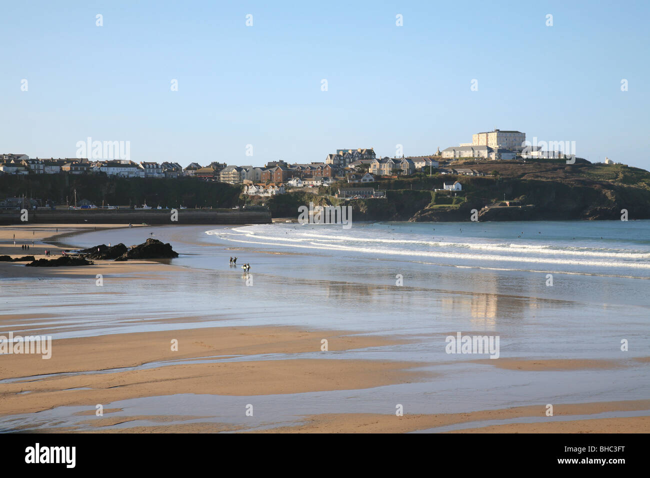 Strand in Newquay Cornwall an einem schönen Wintertag mit Passanten Hunde und nassen Sand Atlantic Hotel im Hintergrund Stockfoto