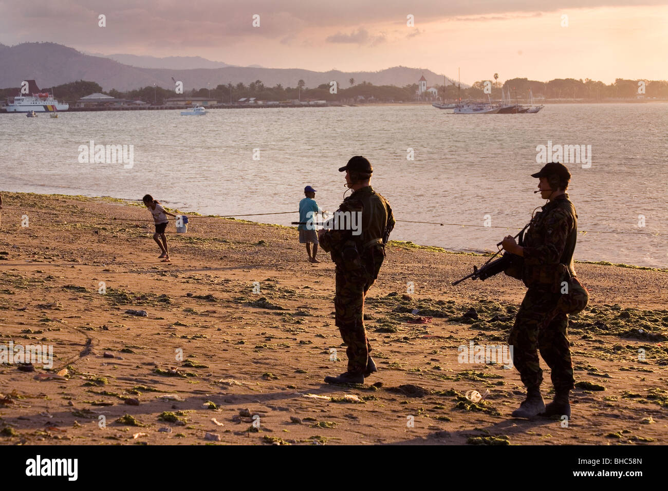 UN bewaffnete Truppen patrouillieren Dili Strand bei Sonnenuntergang Ost-Timor Stockfoto