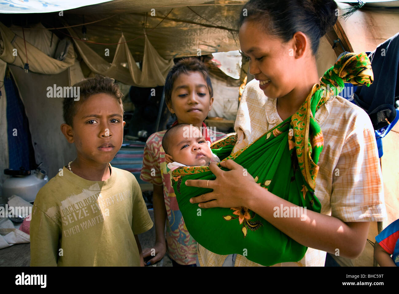 Junge Mutter mit ihrem Baby in engen Zelten für Vertriebene in Dili Krankenhaus IDP Camp Osttimor Leben Stockfoto