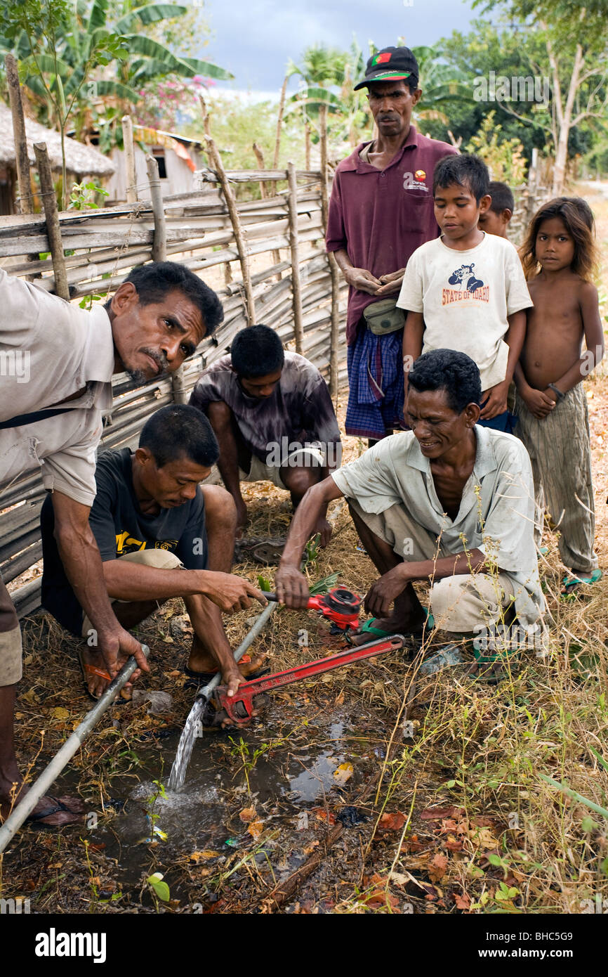 Arbeiter, die Installation geleitet Wasser in ein Dorf in den Bergen in Ost-Timor, beobachtet von der lokalen Bevölkerung Stockfoto