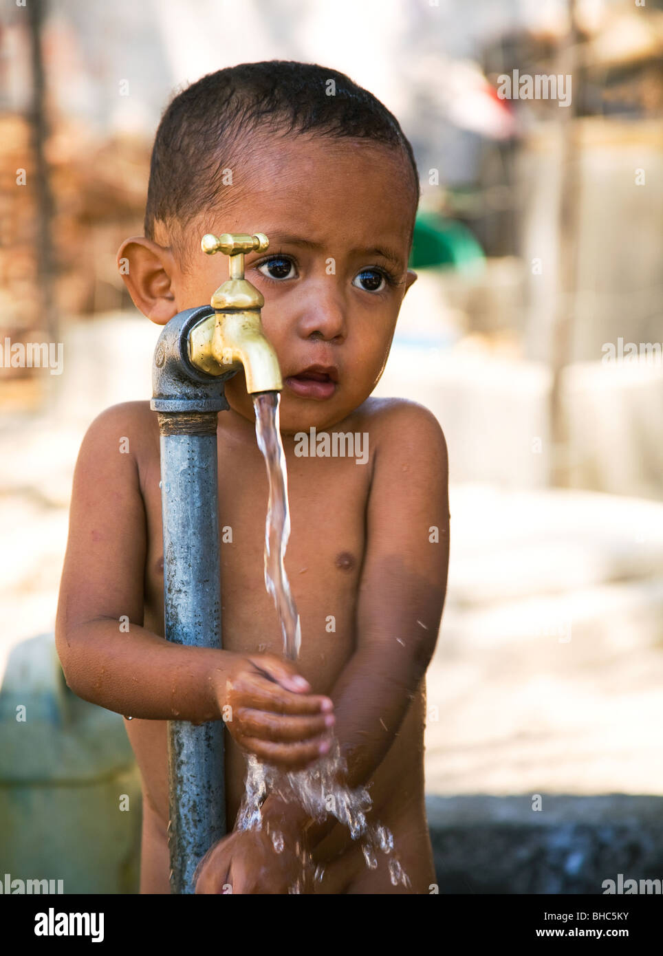 Kleinkind Jungen mit neu installierten Leitungswasser ein IDP Displaced persons Camp in Osttimor in Dili Stockfoto