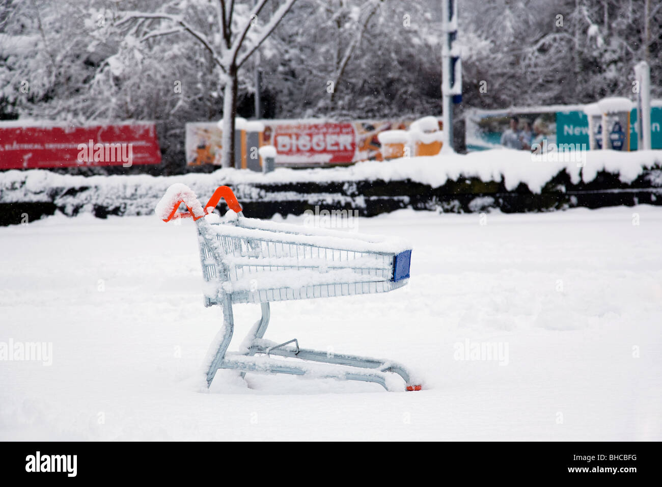 Ein verlassener Einkaufswagen verließ auf einem Supermarkt-Parkplatz nach starkem Schneefall. Stockfoto