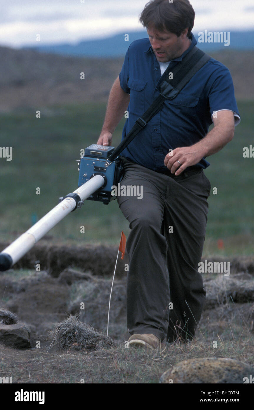 US-amerikanischer Archäologe arbeitet mit einem Gerät die alte Mauern, die u-Bahn in der Nähe von Saudarkrokur, Island erkennen kann. Stockfoto