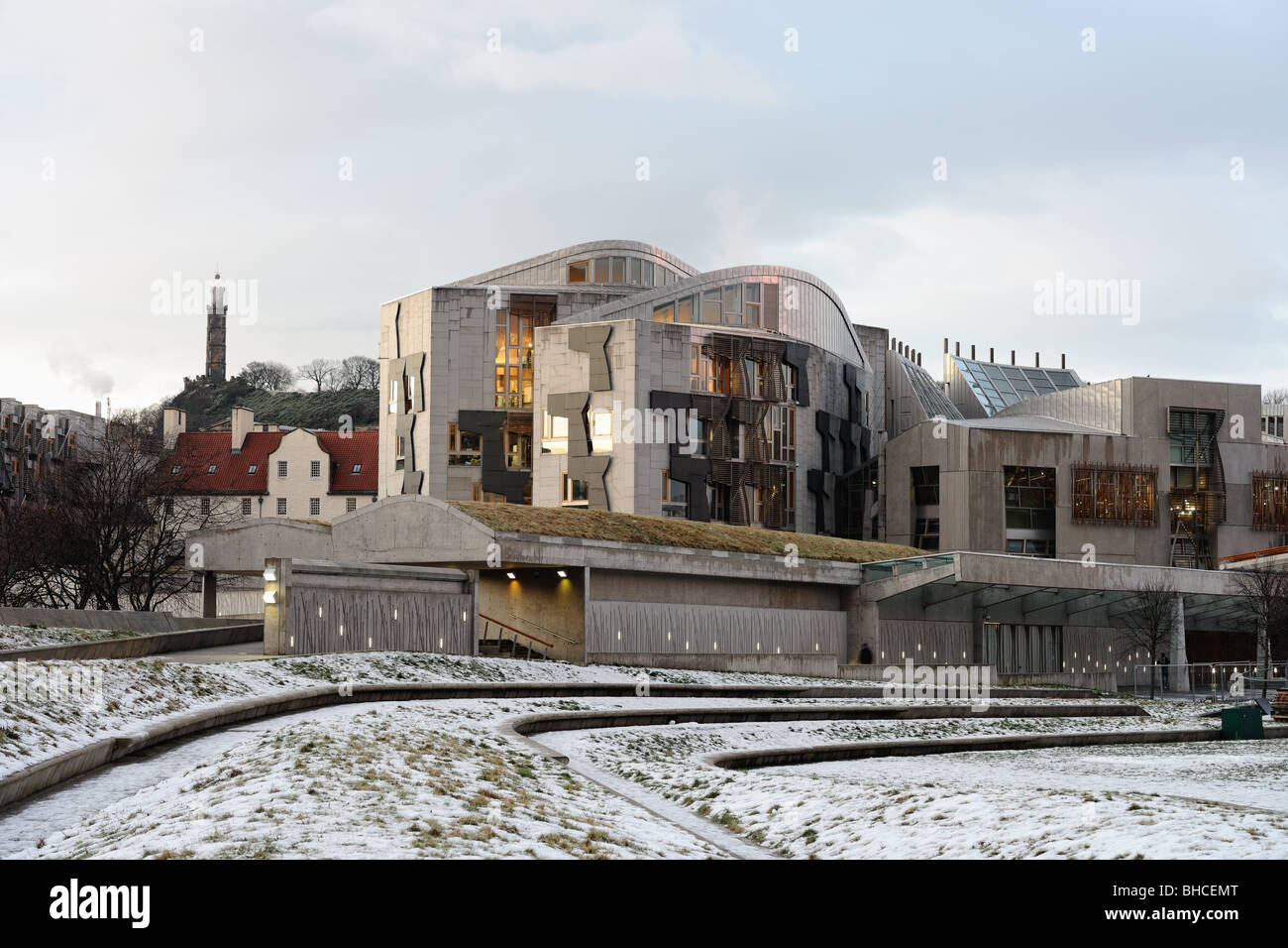 Schottisches Parlament, Holyrood, Edinburgh, Scotland, UK, im Schnee in der Abenddämmerung. Calton Hill ist im Hintergrund. Stockfoto