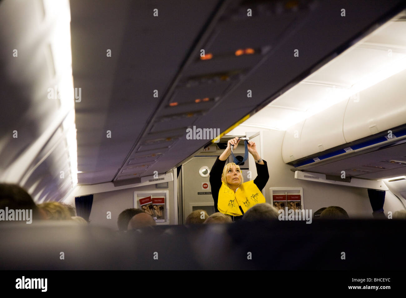 Stewardess veranschaulicht, wie Sicherheitsgurte während des Fluges. Stockfoto