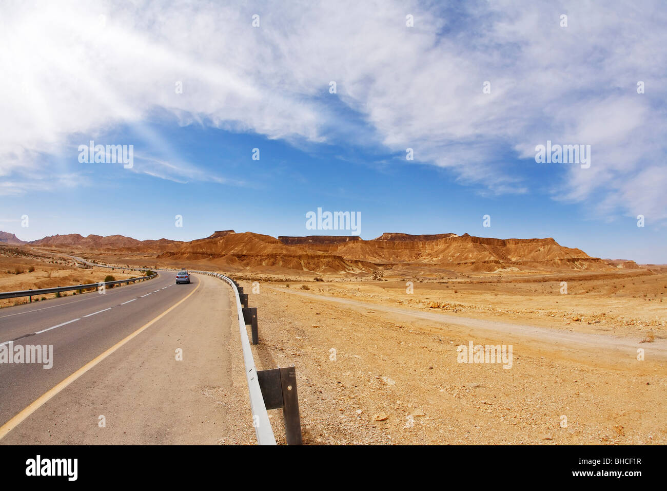 Das Auto auf der leeren Autobahn in Steinwüste Stockfoto