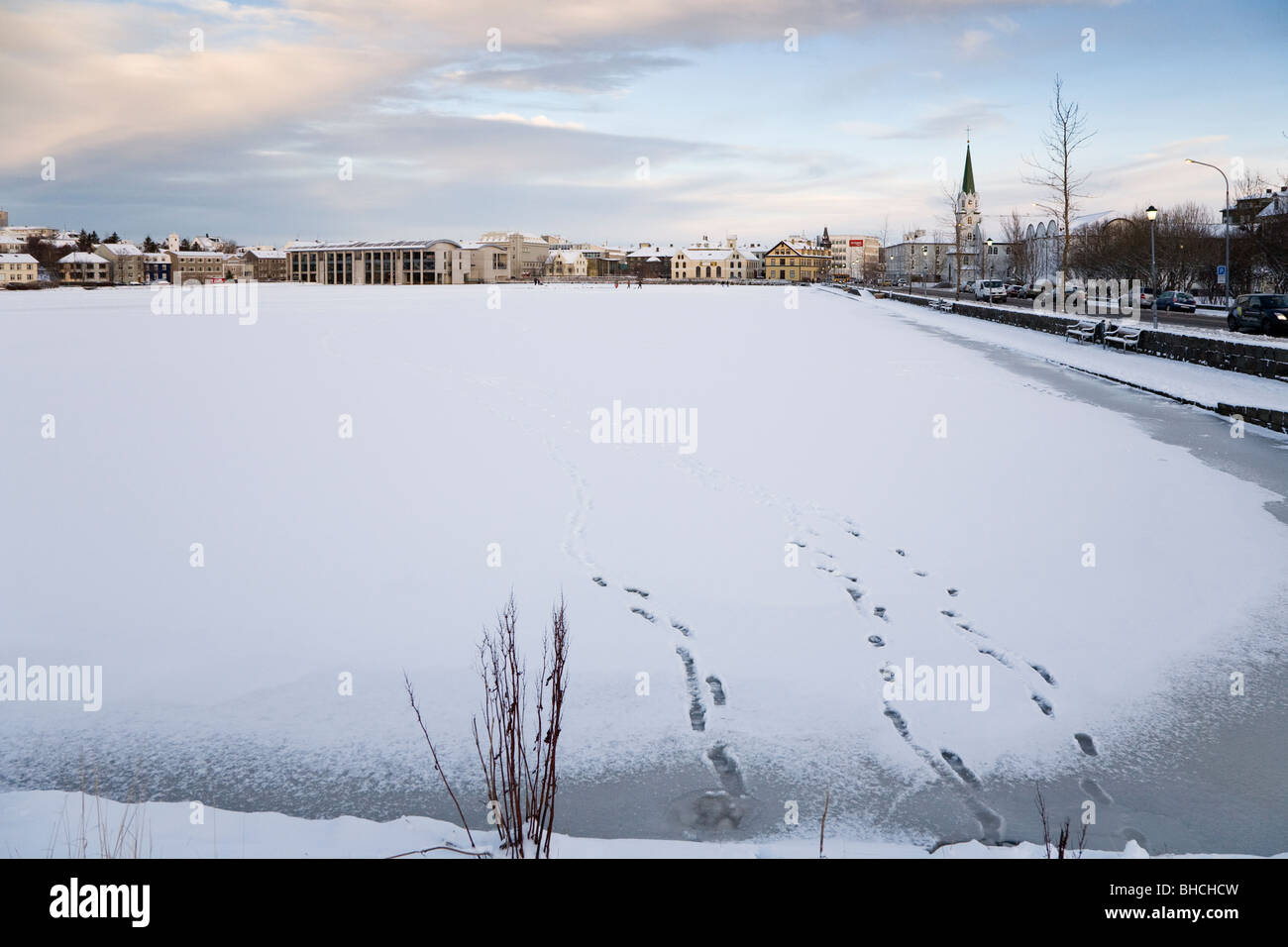 Fußabdrücke auf zugefrorenen See Tjörnin. Die Innenstadt von Reykjavik Island Stockfoto