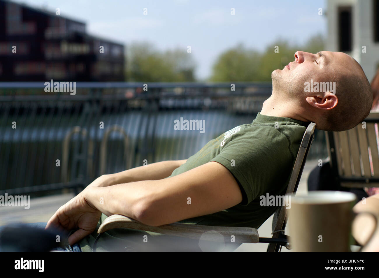 Betrunkener Mann schlafen und Sonnenbaden in Canary Wharf. London Stockfoto