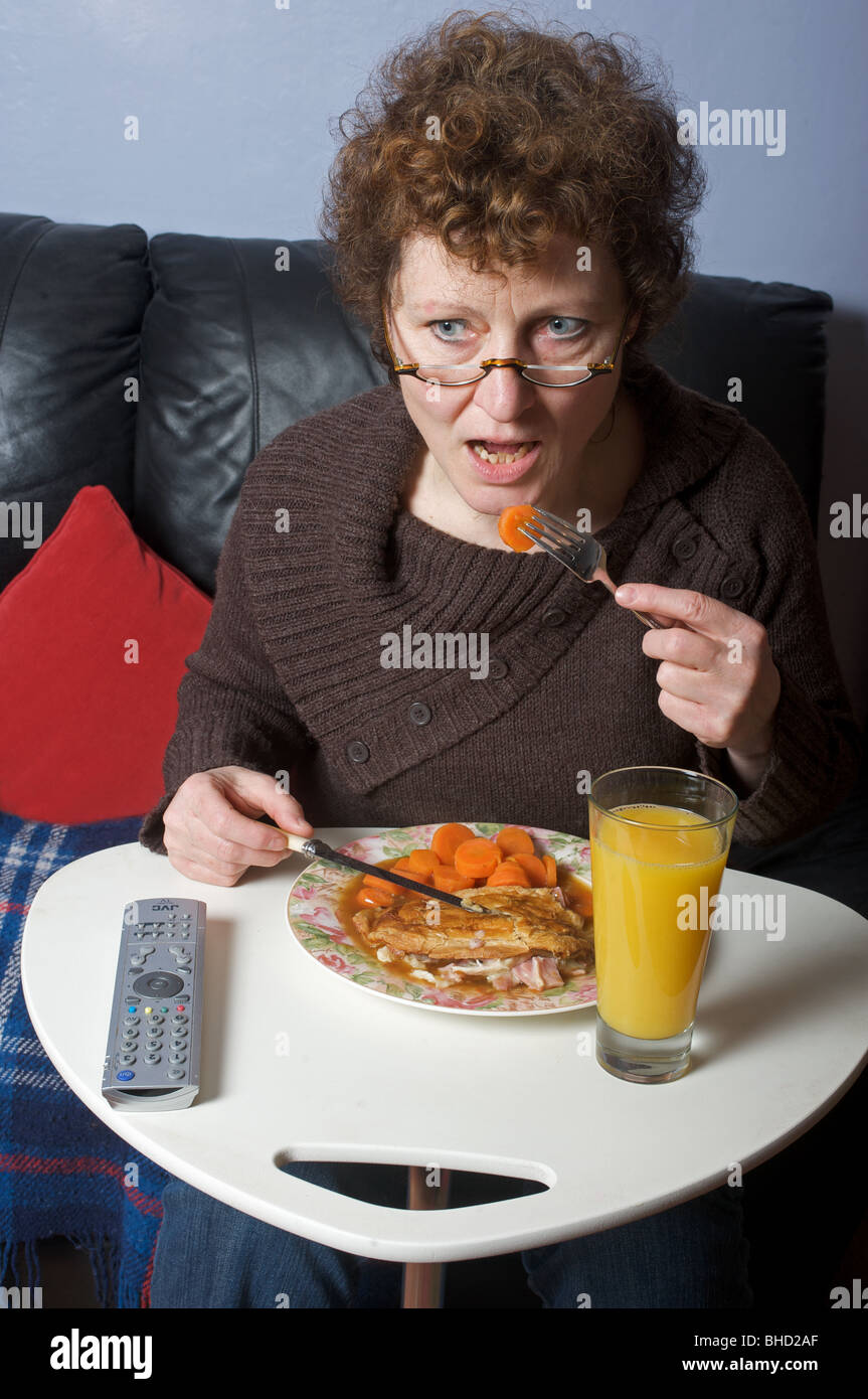 Single-Frau beim Abendessen vor dem Fernseher Stockfoto