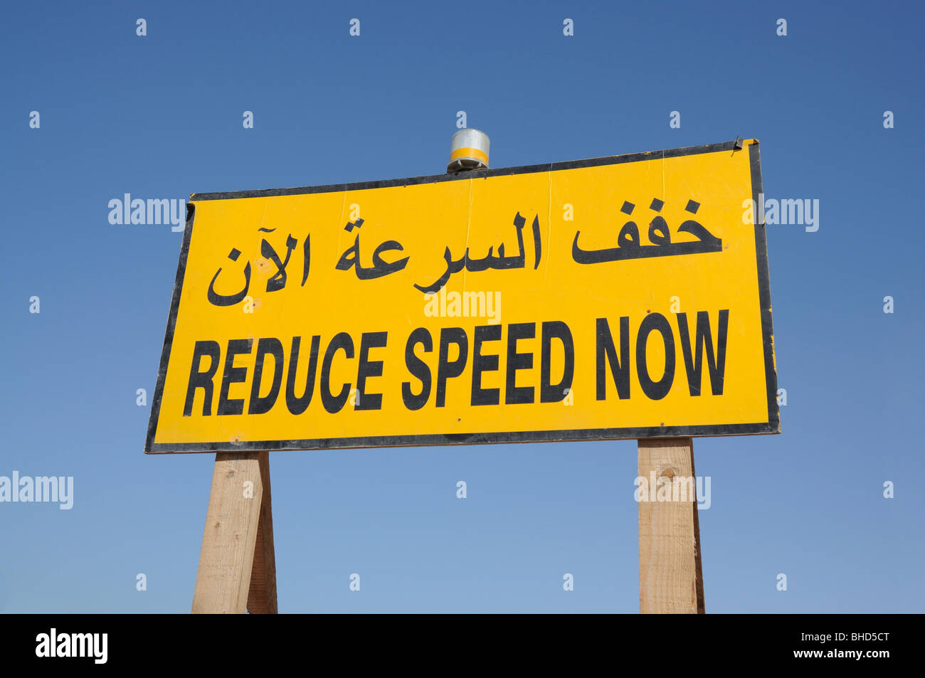 Reduzieren Sie die Geschwindigkeit jetzt Zeichen in englischer und arabischer Sprache. Dubai, Vereinigte Arabische Emirate Stockfoto