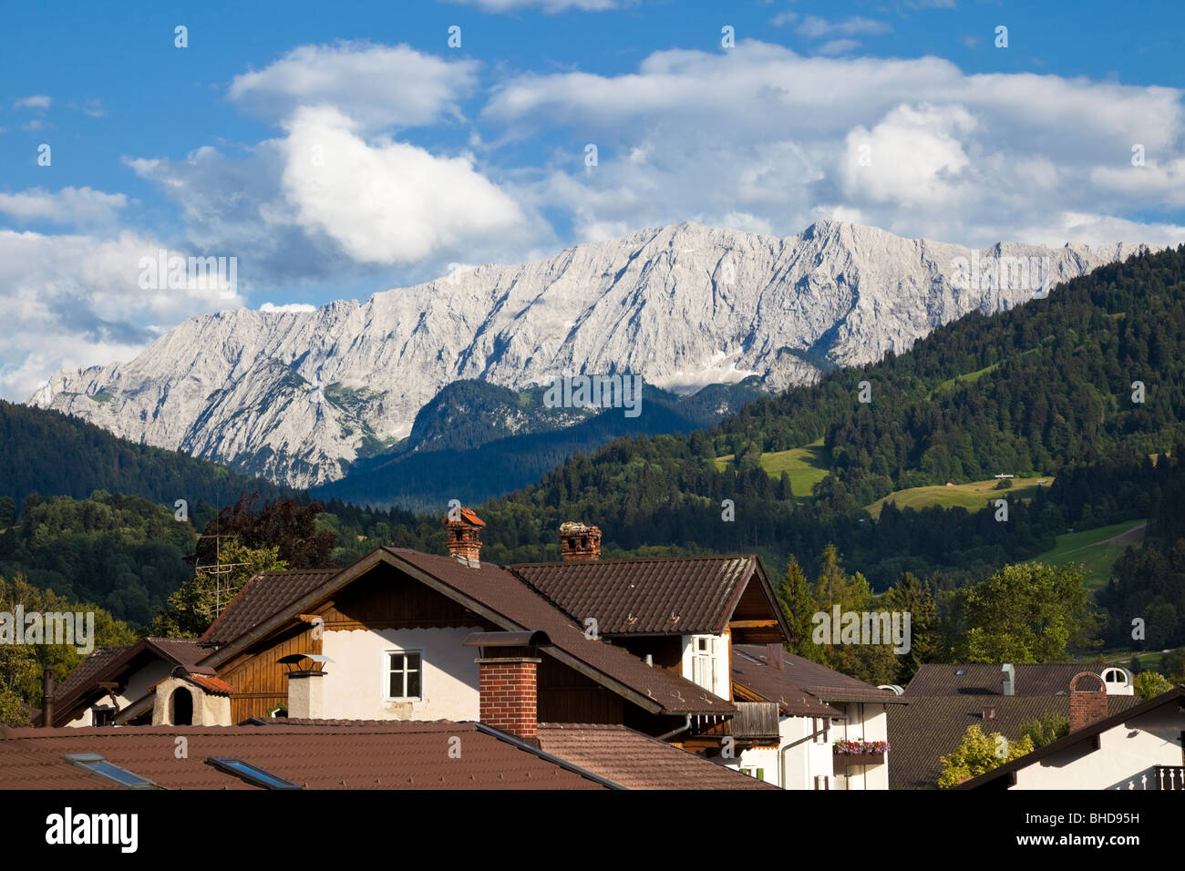 Deutsche Alpen, Deutschland, Bayern - Wettersteinberge mit Dächern von Garmisch-Partenkirchen in den Bayerischen Alpen, Europa im Sommer Stockfoto
