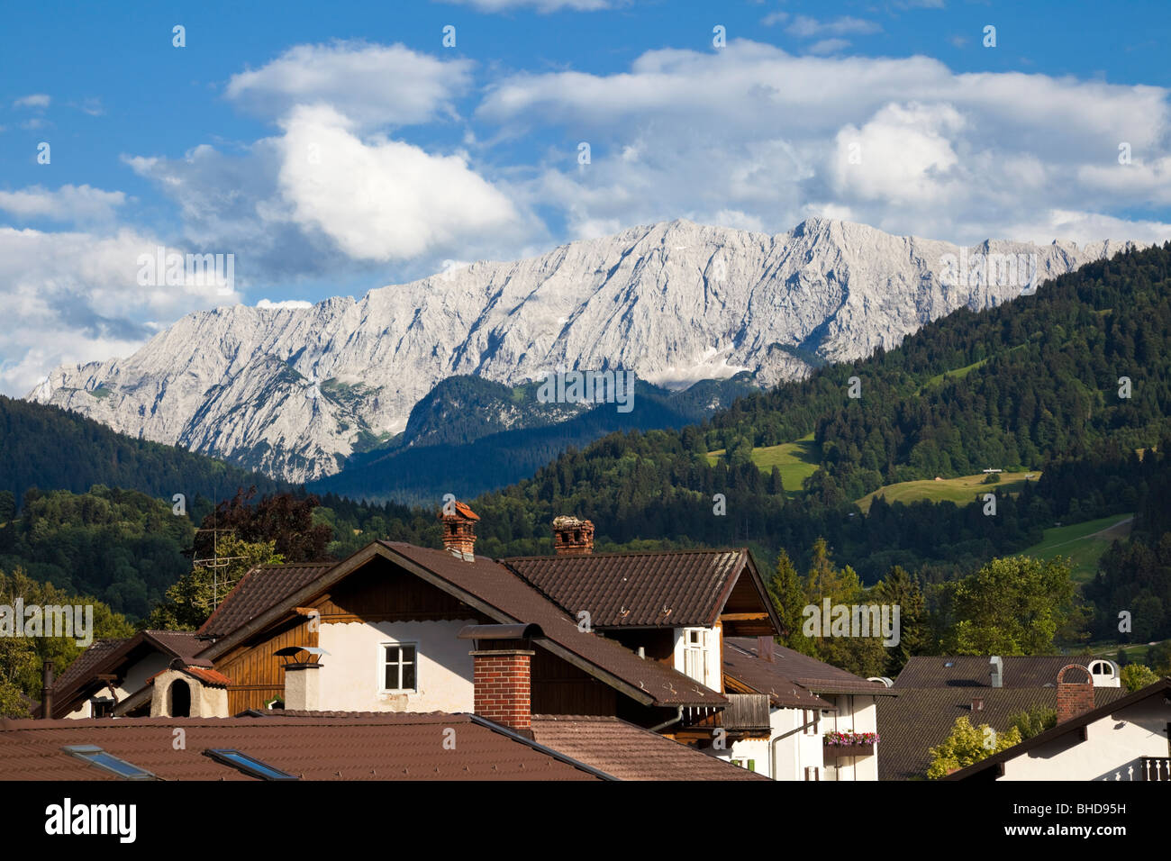 Wettersteingebirge mit Dächer von Garmisch-Partenkirchen in den Bayerischen Alpen, Bayern, Deutschland, Europa im Sommer Stockfoto