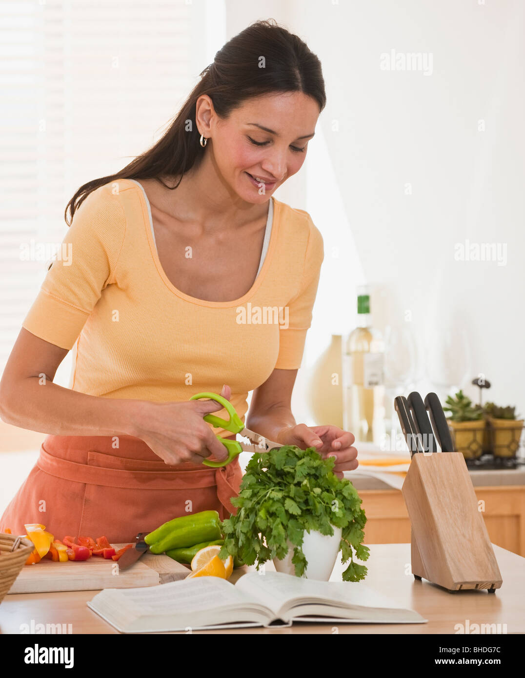 Hispanic Frau schneiden Kräuter Stockfoto