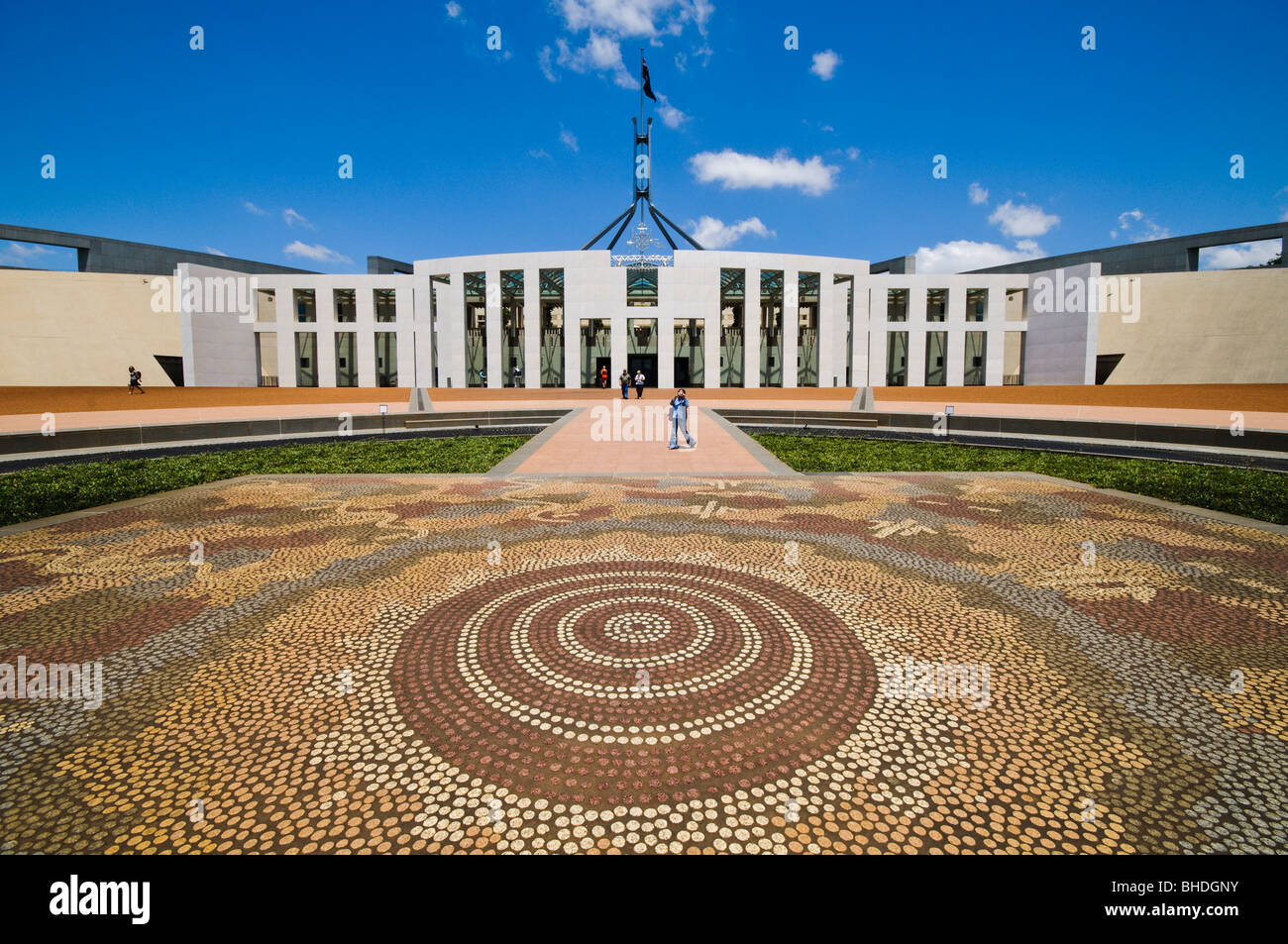 Possum and Wallaby Dreaming Mosaic Canberra Australien // CANBERRA, Australien — der Vorplatz des Parlamentsgebäudes in Canberra zeigt ein markantes Mosaik des Warlpiri-Künstlers Michael Nelson Jagamara, bekannt als „Possum and Wallaby Dreaming“. Das zwischen 1986 und 1987 entstandene Mosaik besteht aus über 90.000 Granitfeldern und symbolisiert die tiefe spirituelle Verbindung zwischen den Aborigines und den Torres Strait Islandern und ihren angestammten Ländereien. Das von William McIntosh, Aldo Rossi und Franco Colussi erarbeitete Kunstwerk erinnert an die über 65.000jährige Geschichte Stockfoto