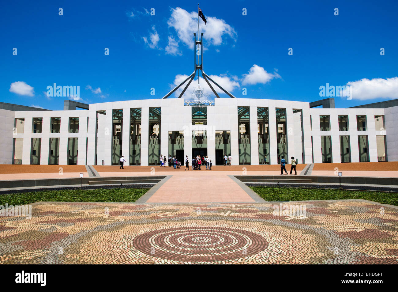 CANBERRA, Australien — der Vorplatz des Parlamentsgebäudes in CANBERRA zeigt ein markantes Mosaik des Warlpiri-Künstlers Michael Nelson Jagamara, bekannt als „Possum and Wallaby Dreaming“. Das zwischen 1986 und 1987 entstandene Mosaik besteht aus über 90.000 Granitfeldern und symbolisiert die tiefe spirituelle Verbindung zwischen den Aborigines und den Torres Strait Islandern und ihren angestammten Ländereien. Das Kunstwerk, das von William McIntosh, Aldo Rossi und Franco Colussi gefertigt wurde, erinnert an die über 65.000-jährige Präsenz der Ureinwohner Stockfoto