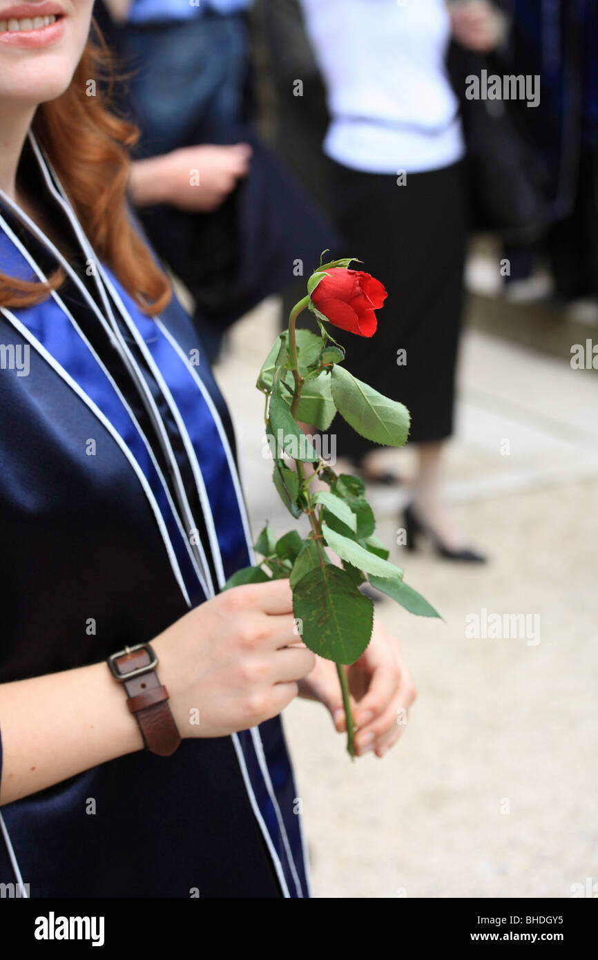 Ein Absolvent, die rote rose in der Hand halten Stockfoto
