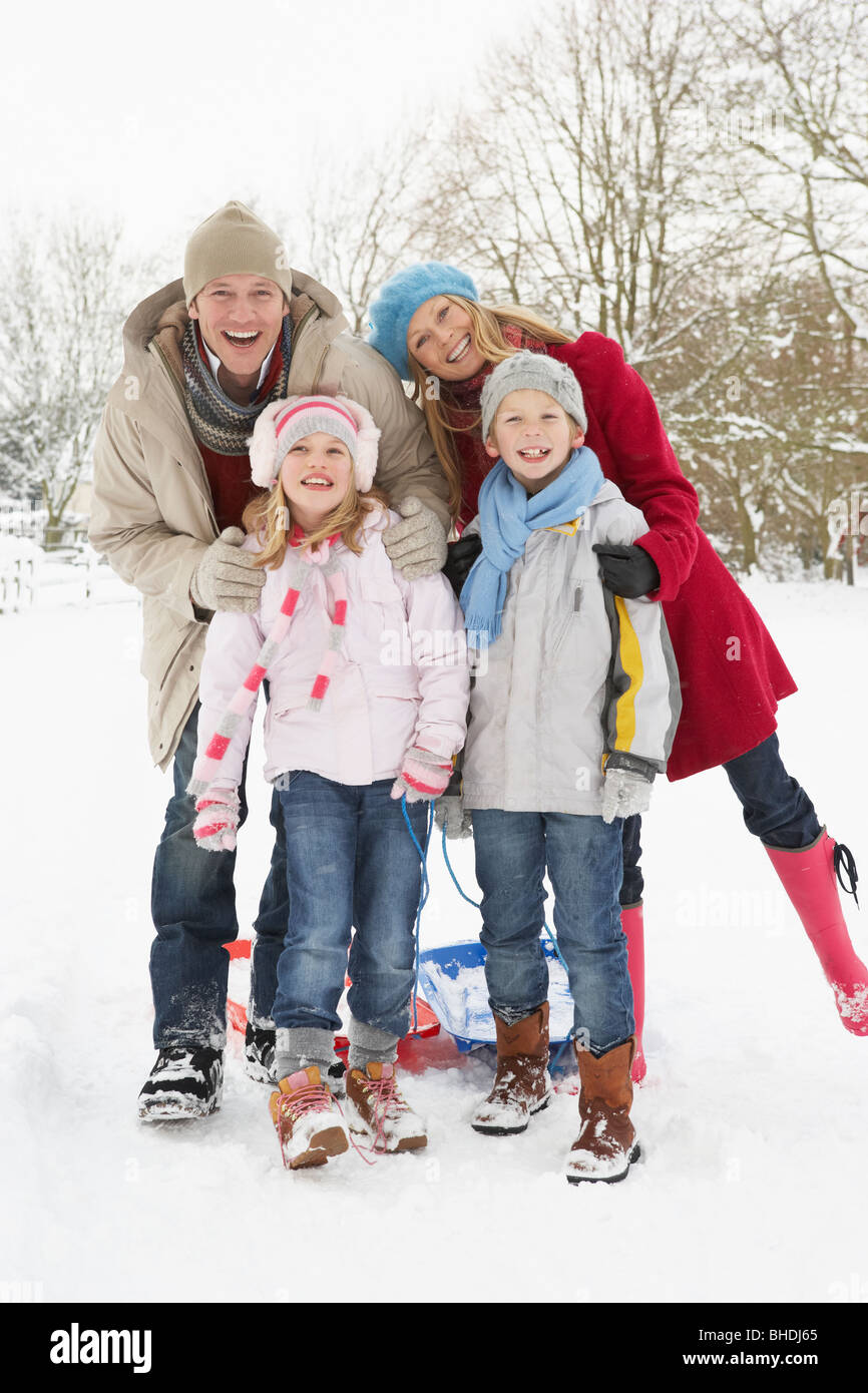 Familie ziehen Schlitten durch tief verschneite Landschaft Stockfoto