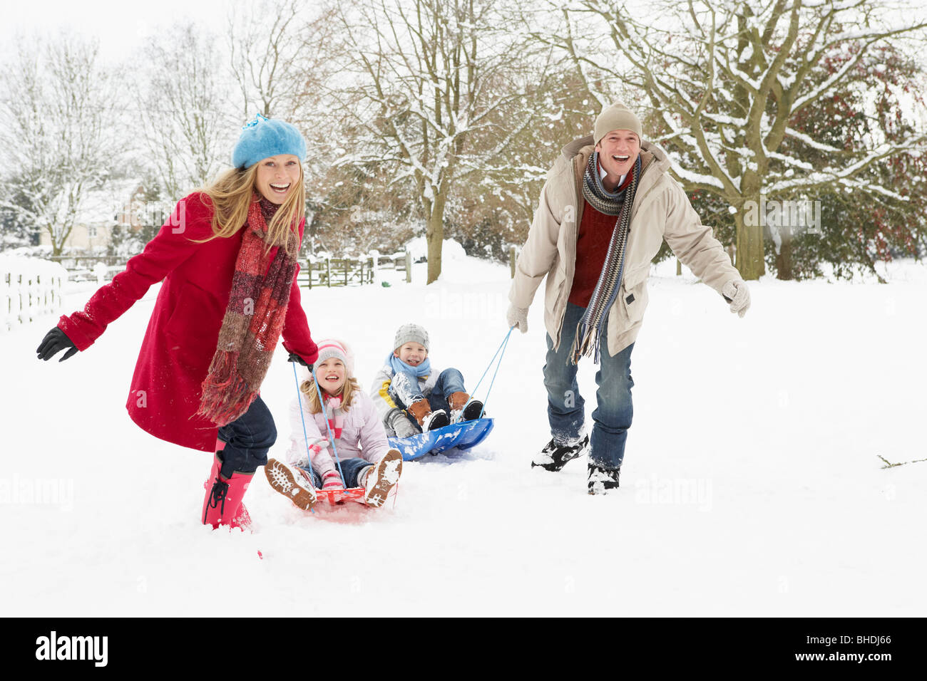 Familie ziehen Schlitten durch tief verschneite Landschaft Stockfoto