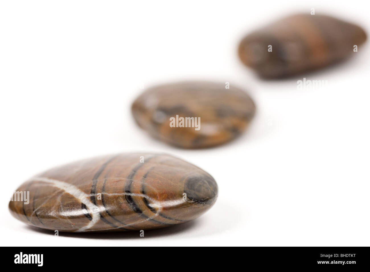 Nahaufnahme von glänzenden braunen Zen Steinen isoliert auf weißem Hintergrund Stockfoto