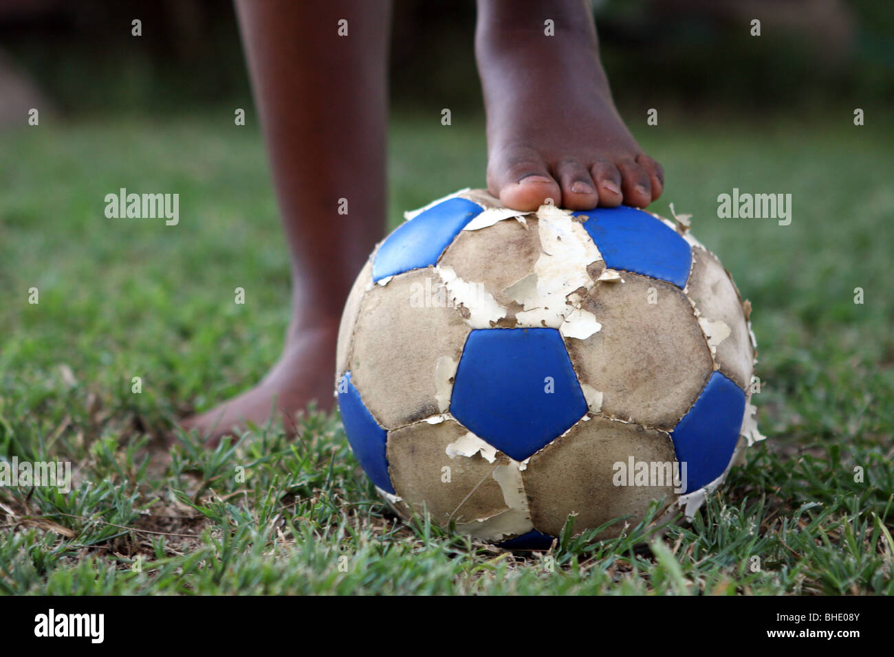 Eine Person steht mit einem Fußball zu ihren Füßen auf einem Fußballplatz in Südafrika Stockfoto