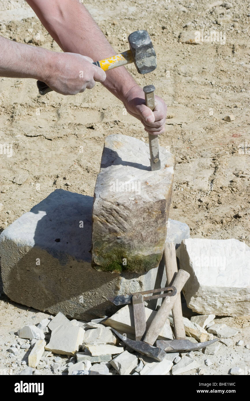 Ein Steinmetz nutzt Hammer und Meißel, um einen großen Stein zu brechen  Stockfotografie - Alamy