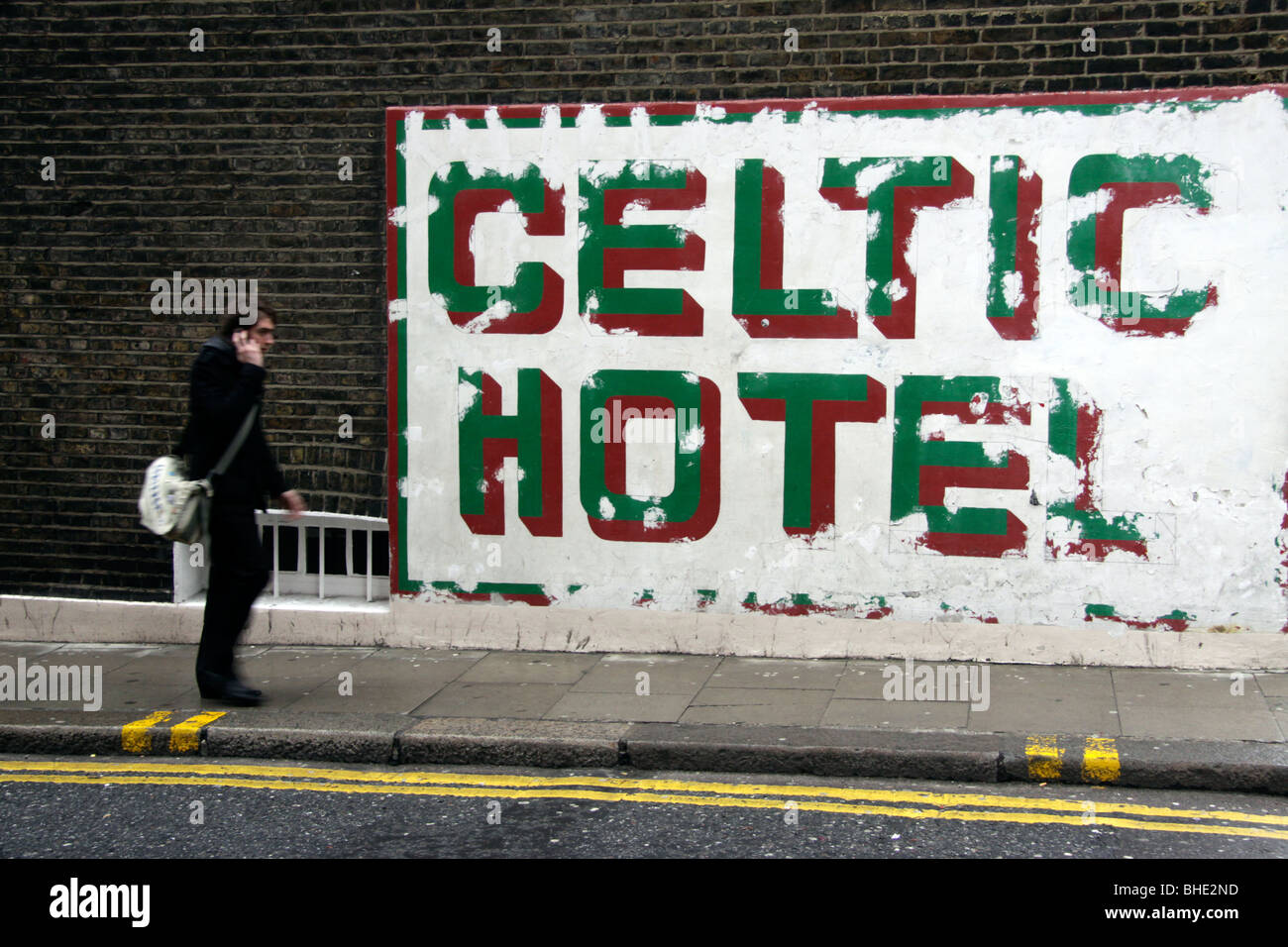 Mann auf Handy zu Fuß vorbei an der Keltischen Hotel in Russel Square, London Stockfoto