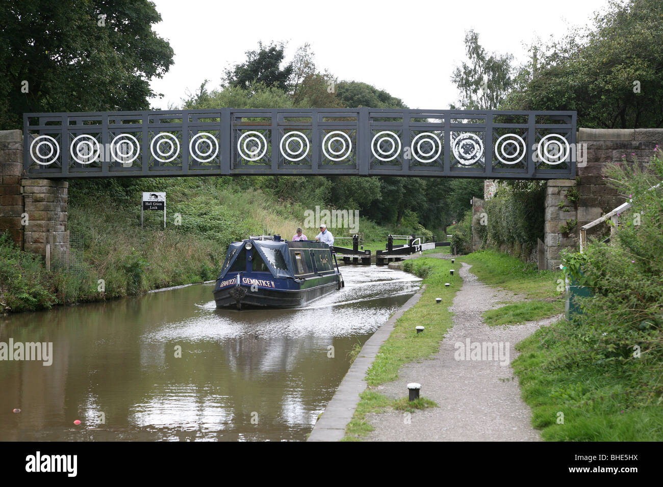 Ein Kanal Barge oder schmalen Boot auf der Macclesfield Kanal gehen unter einer Brücke nur nach dem coming out eines Schlosses. Stockfoto