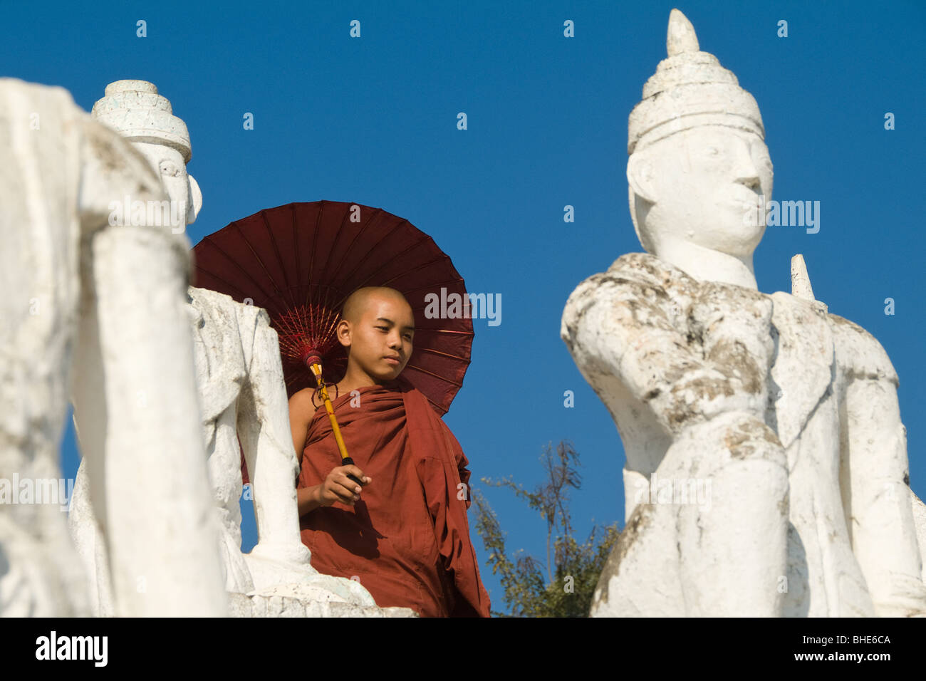 Settawya-Pagode, Young buddhistischer Mönch mit einem roten Regenschirm, Mingun, Burma, Myanmar Stockfoto