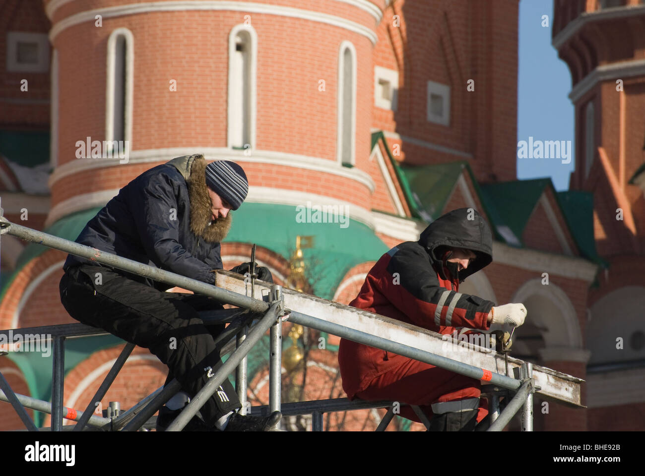 Zwei Arbeiter montieren Metalldesign vorne auf die Moskauer Basilius-Kathedrale Stockfoto