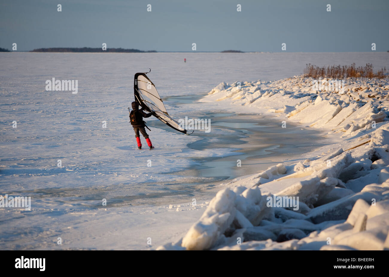 Eine Frau Skifahren auf Eisschollen im Winter mit einem Kitewing an Ostsee, der Bottnische Meerbusen, Finnland Stockfoto