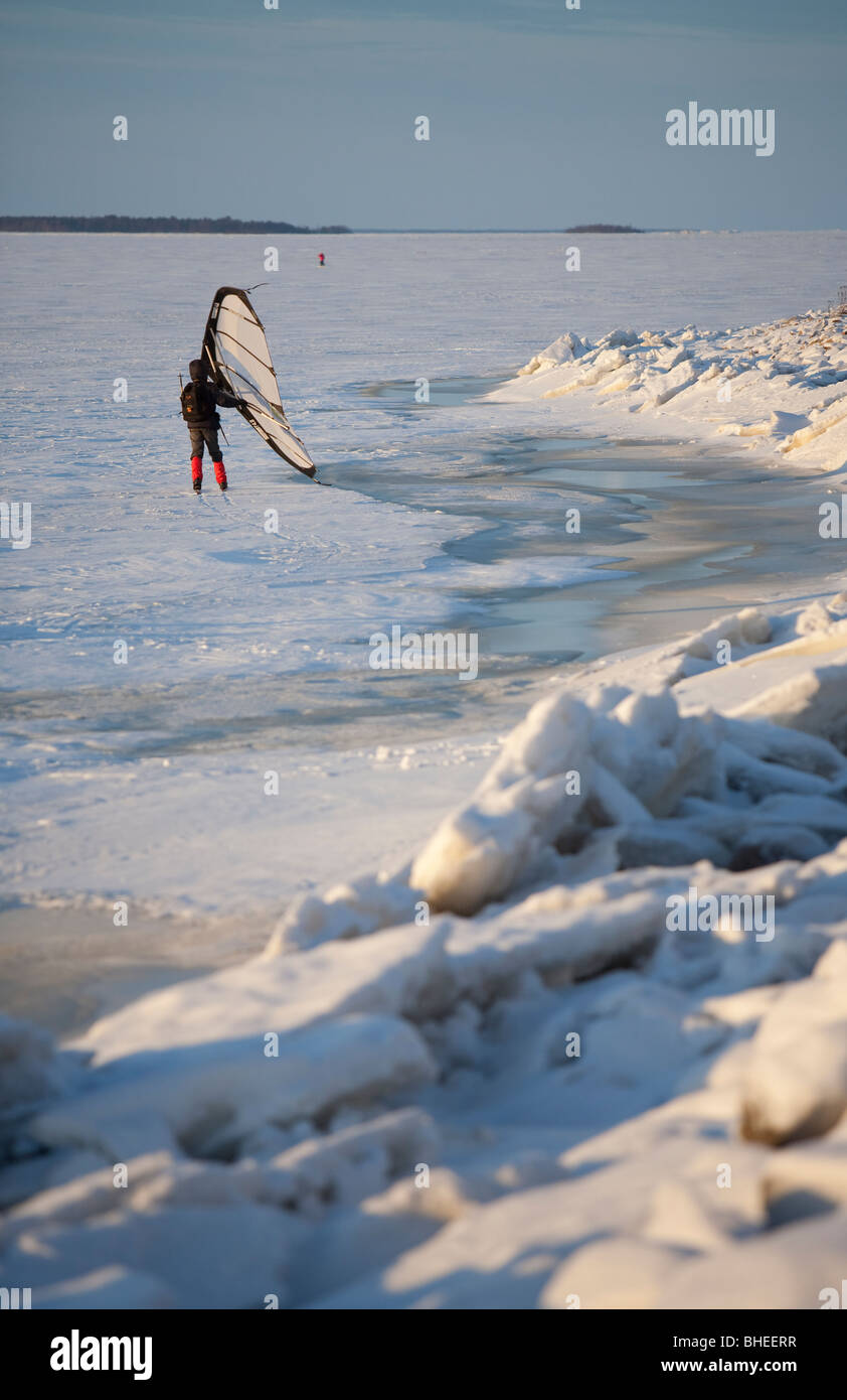 Eine Frau Skifahren auf Eisschollen im Winter mit einem Kitewing an Ostsee, der Bottnische Meerbusen, Finnland Stockfoto