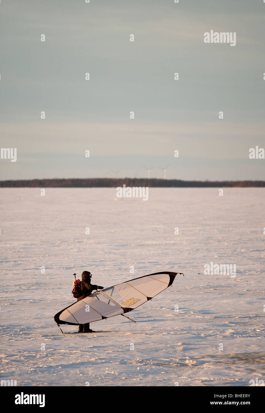 Ein Mann, Skifahren auf dem Meereis im Winter mit einem Kitewing an Ostsee, der Bottnische Meerbusen, Finnland Stockfoto