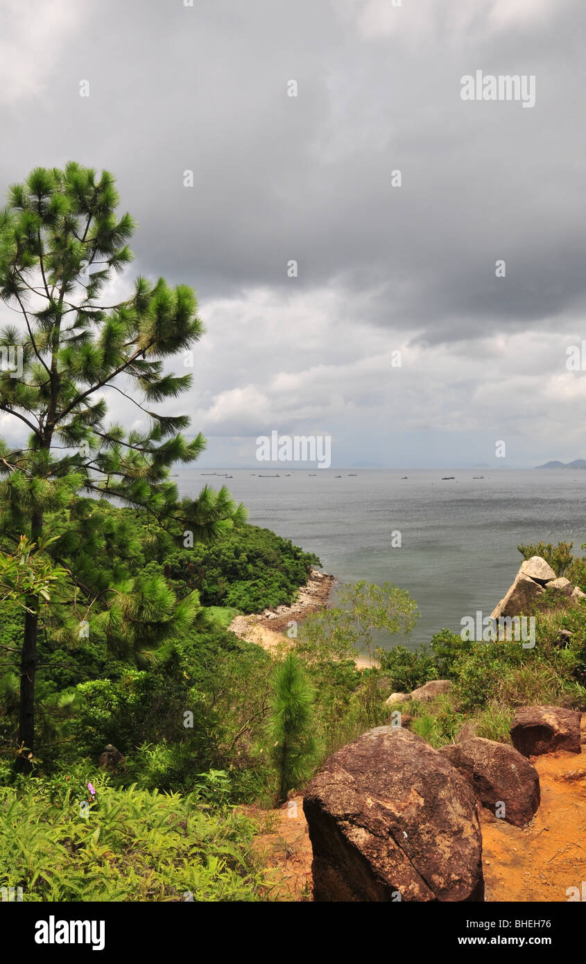 Dunkle Wolke Südchinesische Meer Porträt, Kiefer, Baum, rote Erde, Granit auf einer Klippe in der Nähe von Ling So Shing, Lamma Island, Hong Kong Stockfoto