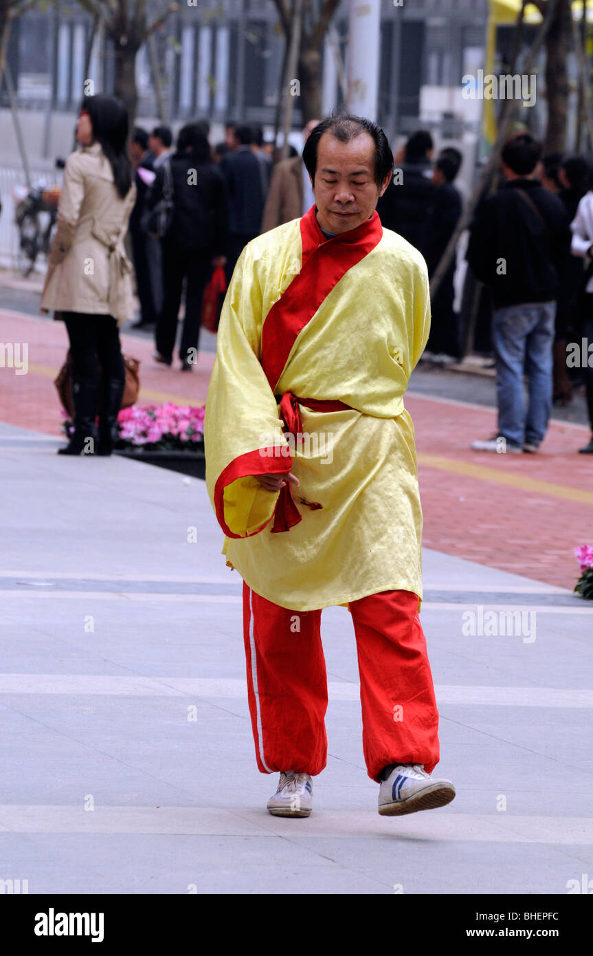 Chinesischer Mann tragen gelbe Seide Jacke auf Straße in Guangzhou, China. Stockfoto