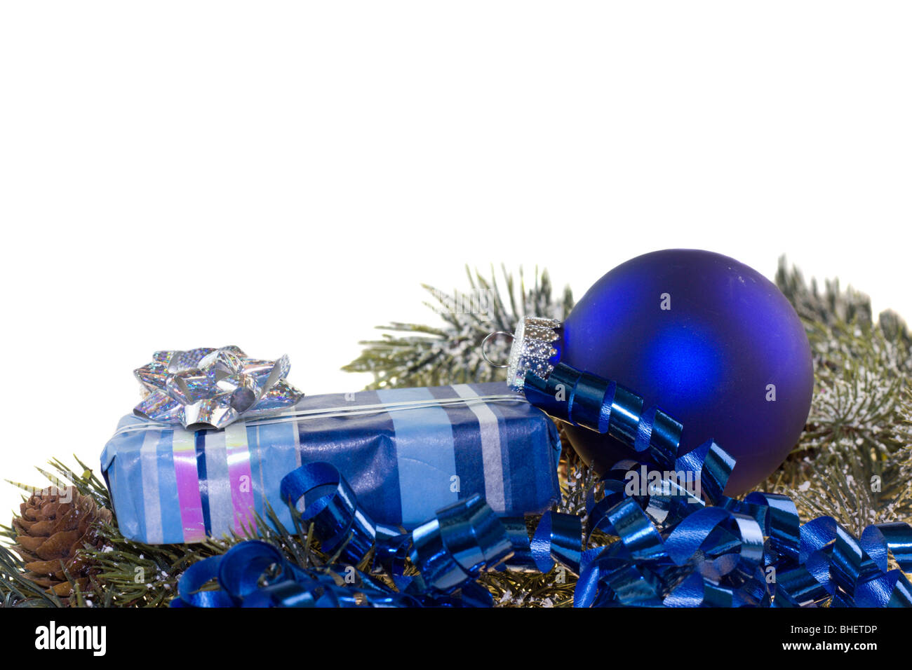 verpackte Weihnachtsgeschenk mit Tand auf Feuer Zweig auf weiß blau Stockfoto