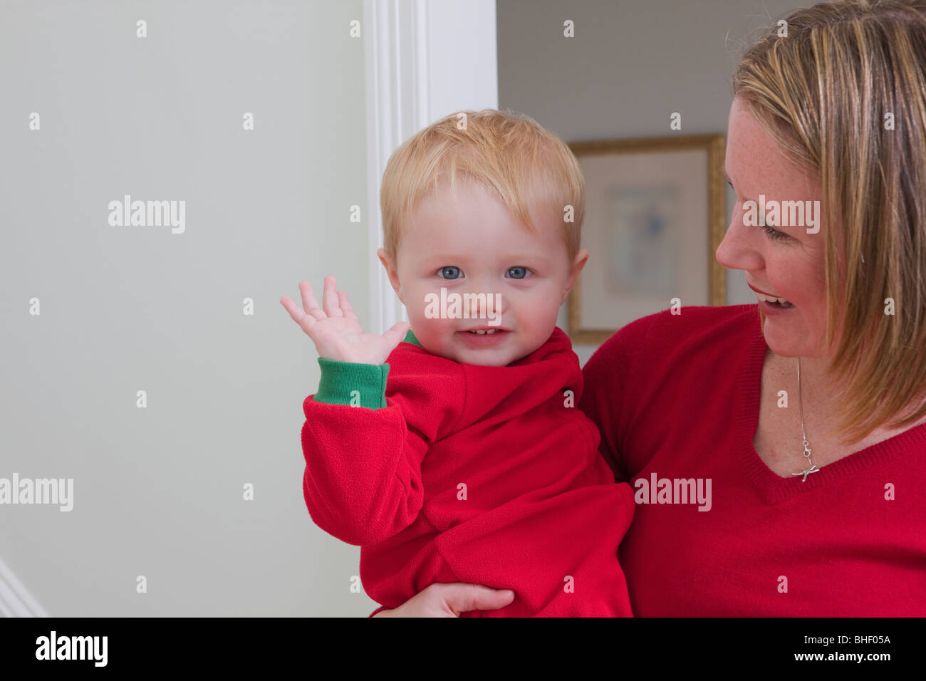 Baby Boy Unterzeichnung das Wort "Mama" in amerikanischer Gebärdensprache in seiner Mutter Schoß Stockfoto