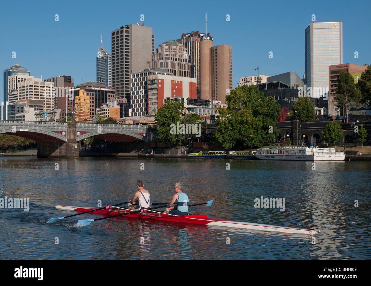 Ruderer auf dem Yarra River vor der Kulisse der Skyline von Melbourne Stockfoto