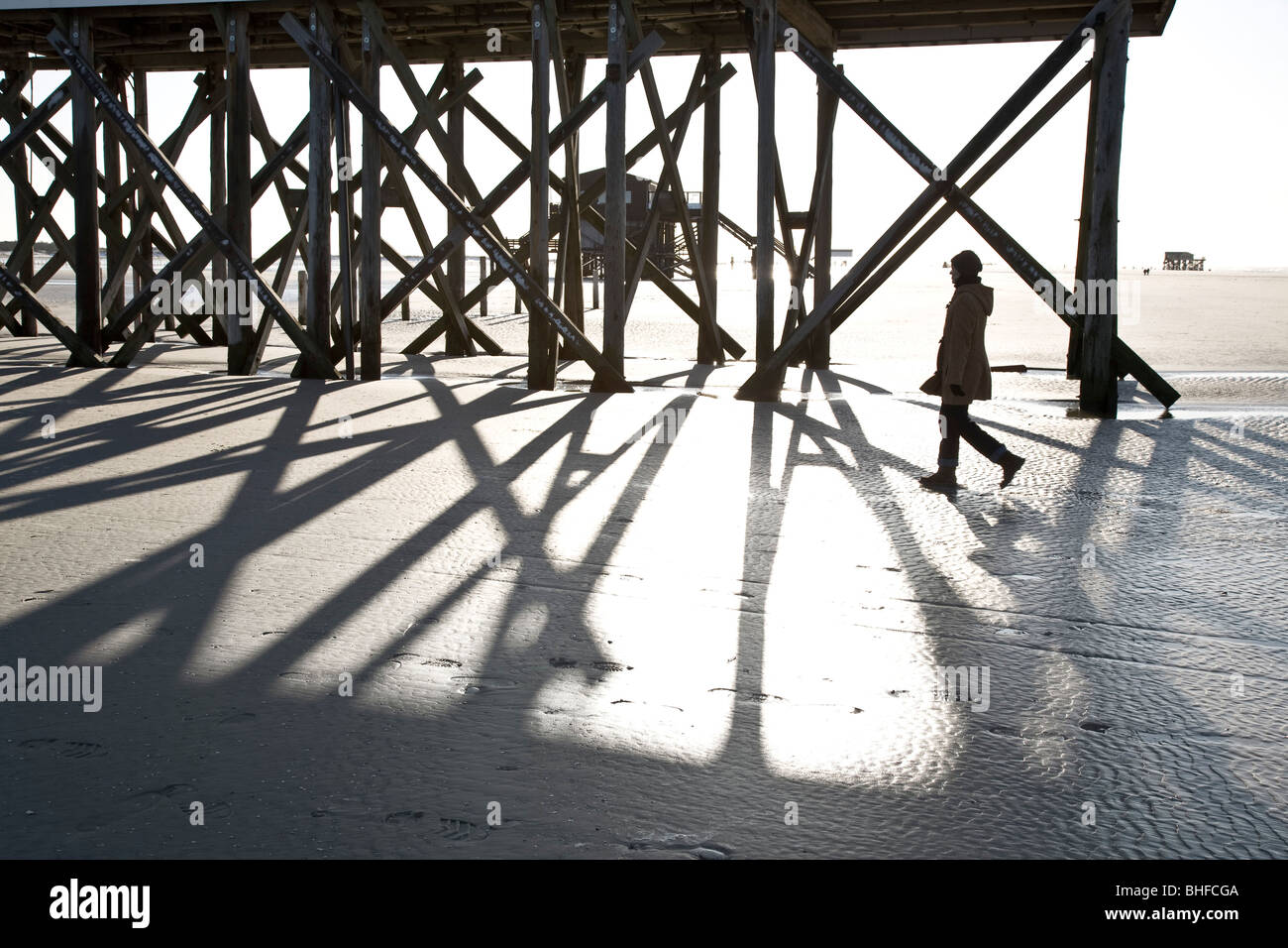 Frau vorbei Stelzenhaus am Strand, St. Peter-Ording, Nationalpark Wattenmeer, Schleswig-Holstein, Deutschland Stockfoto