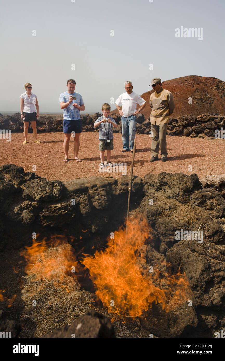 Demonstration von Feuer durch vulkanische Hitze mit Reisig, Parque Nacional de Tiimanfaya, Montanas del Fuego, Parkwächter, Familie, U Stockfoto