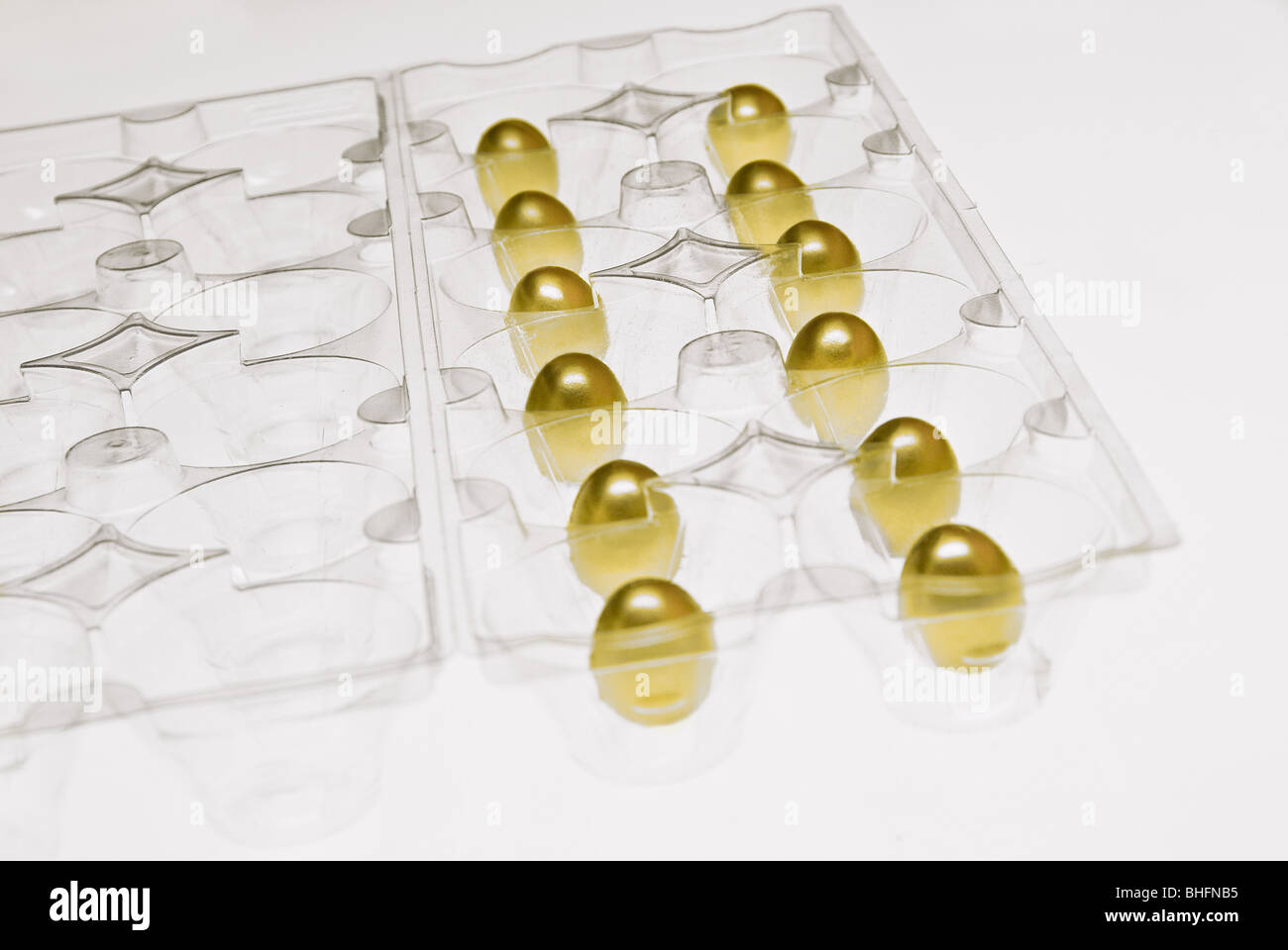 Schrumpfen gold Nest Eiern in Ei-Behälter, Studio gedreht Stockfoto