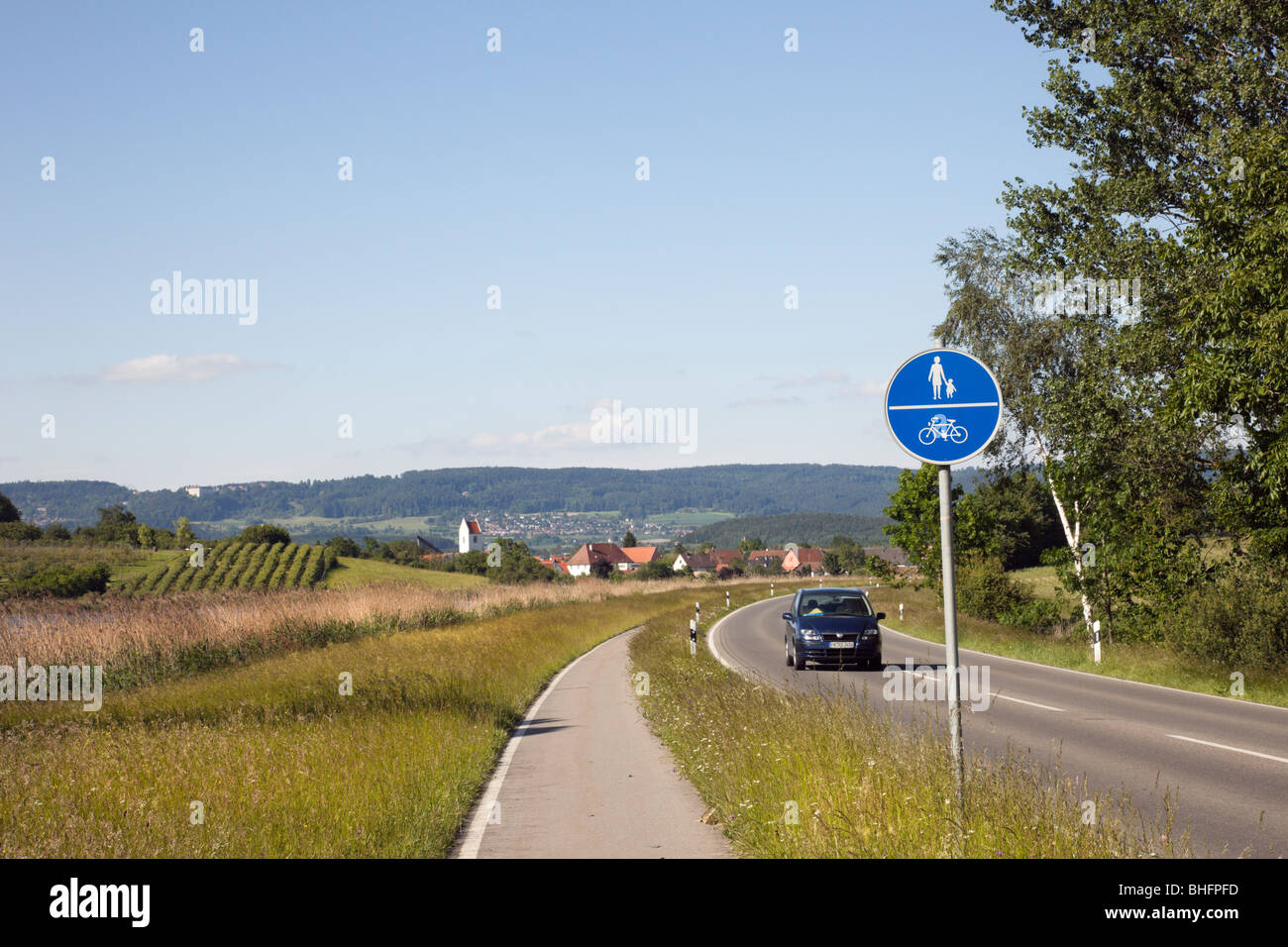 Mimmenhausener, Baden-Württemberg, Deutschland, Europa. Track und Zeichen neben einer Landstraße mit einem Auto, das kleine Dorf verlassen-Zyklus Stockfoto