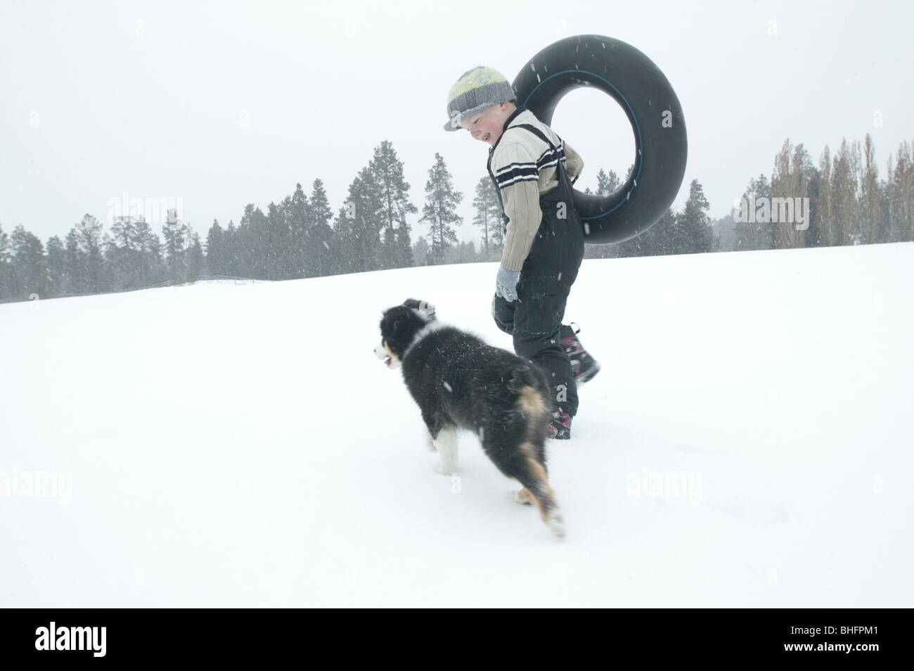 junge Wandern mit Hund im Schnee Stockfoto