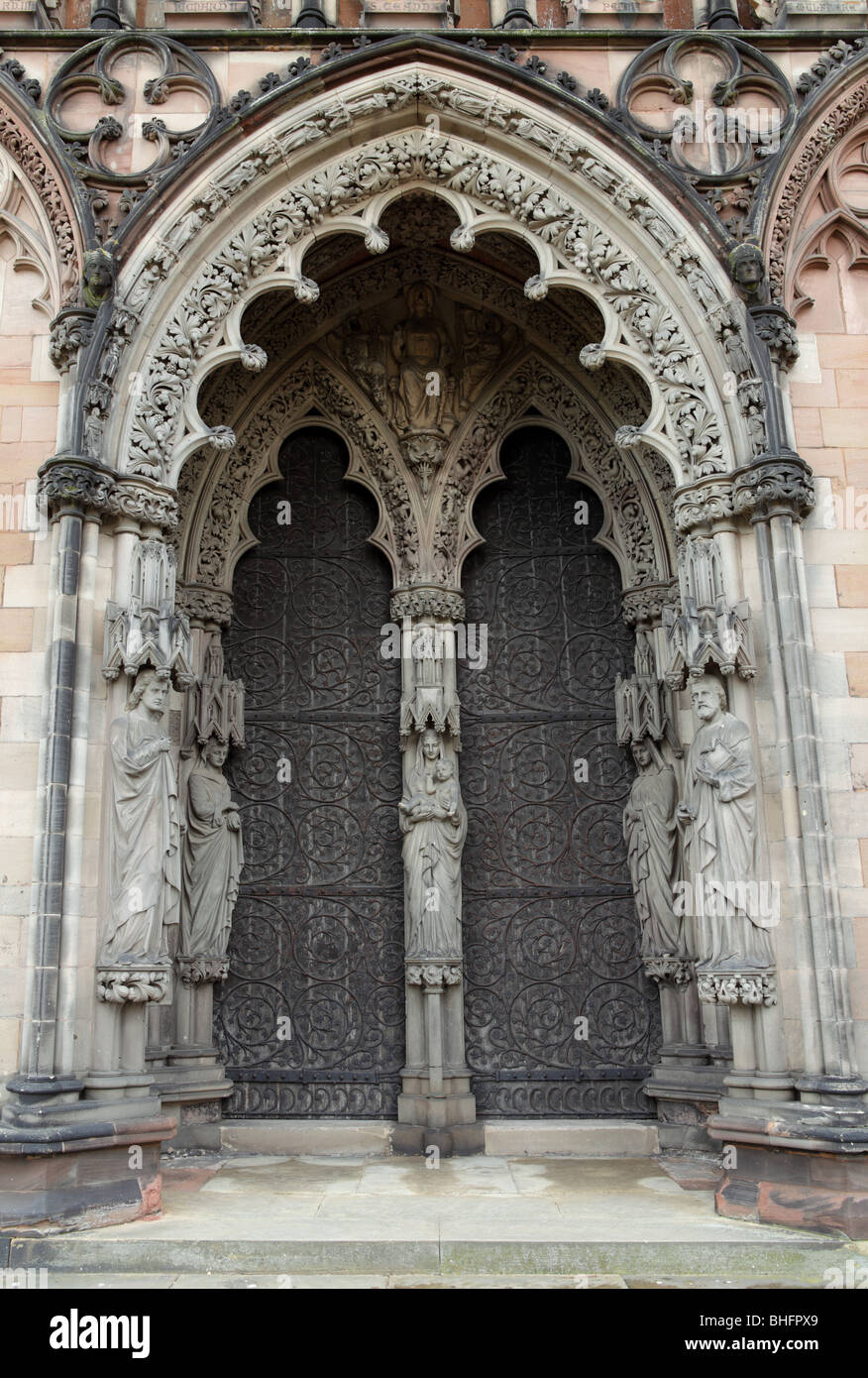 Die große West-Tür und Haupteingang zur Kathedrale von Lichfield, wunderbar geschnitzten Stein, die Gestaltung der riesigen Eiche Türen. Stockfoto