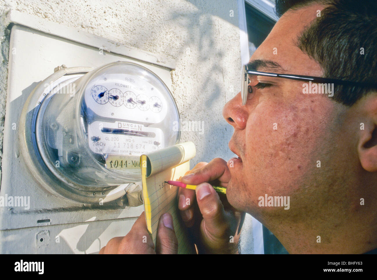 Hispanic Mann lesen Sie Stromzähler Maßnahme Kosten berechnen Rekord macht Energie Stockfoto