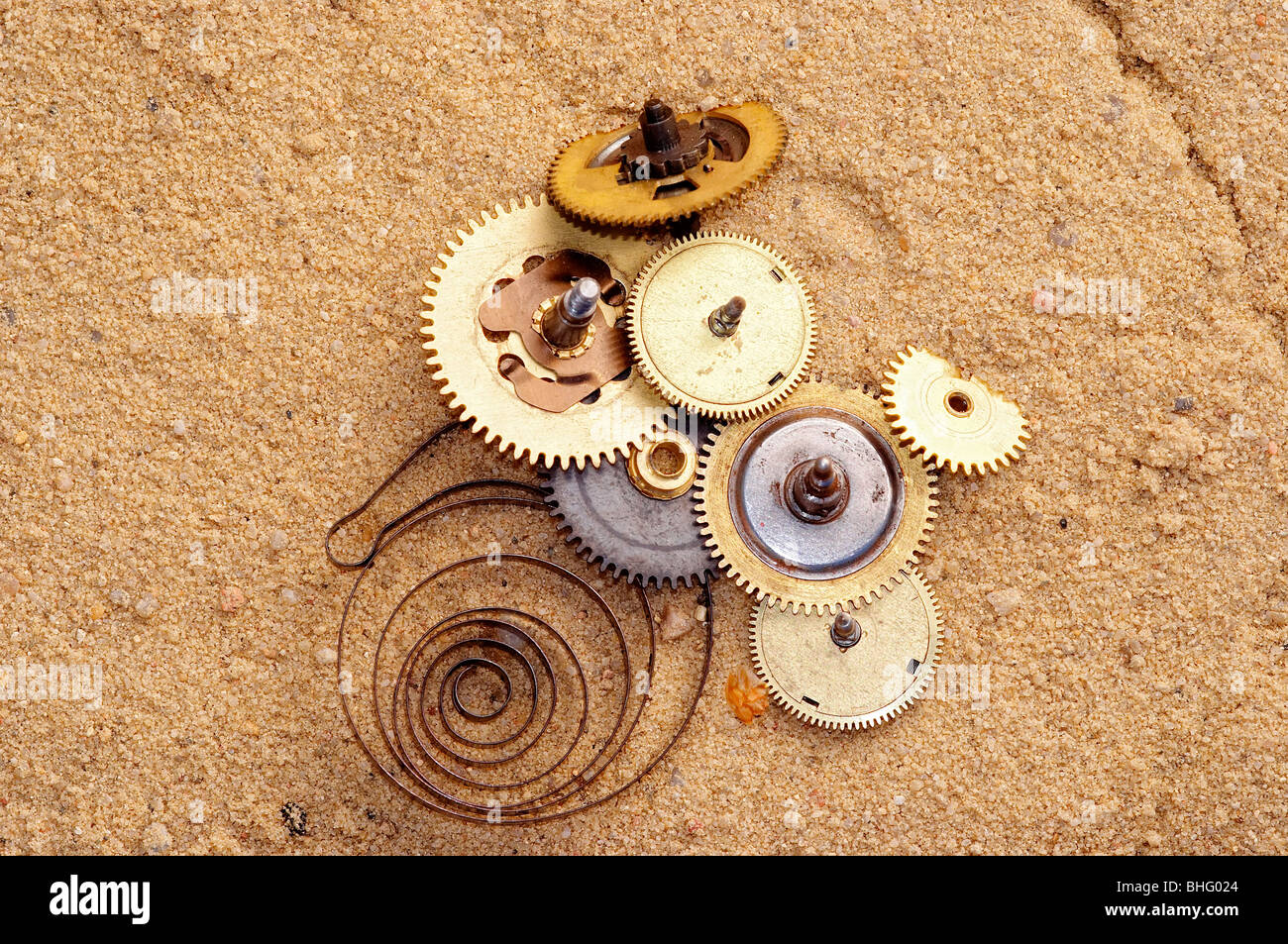 Teile des Uhrwerk auf dem sand Stockfoto